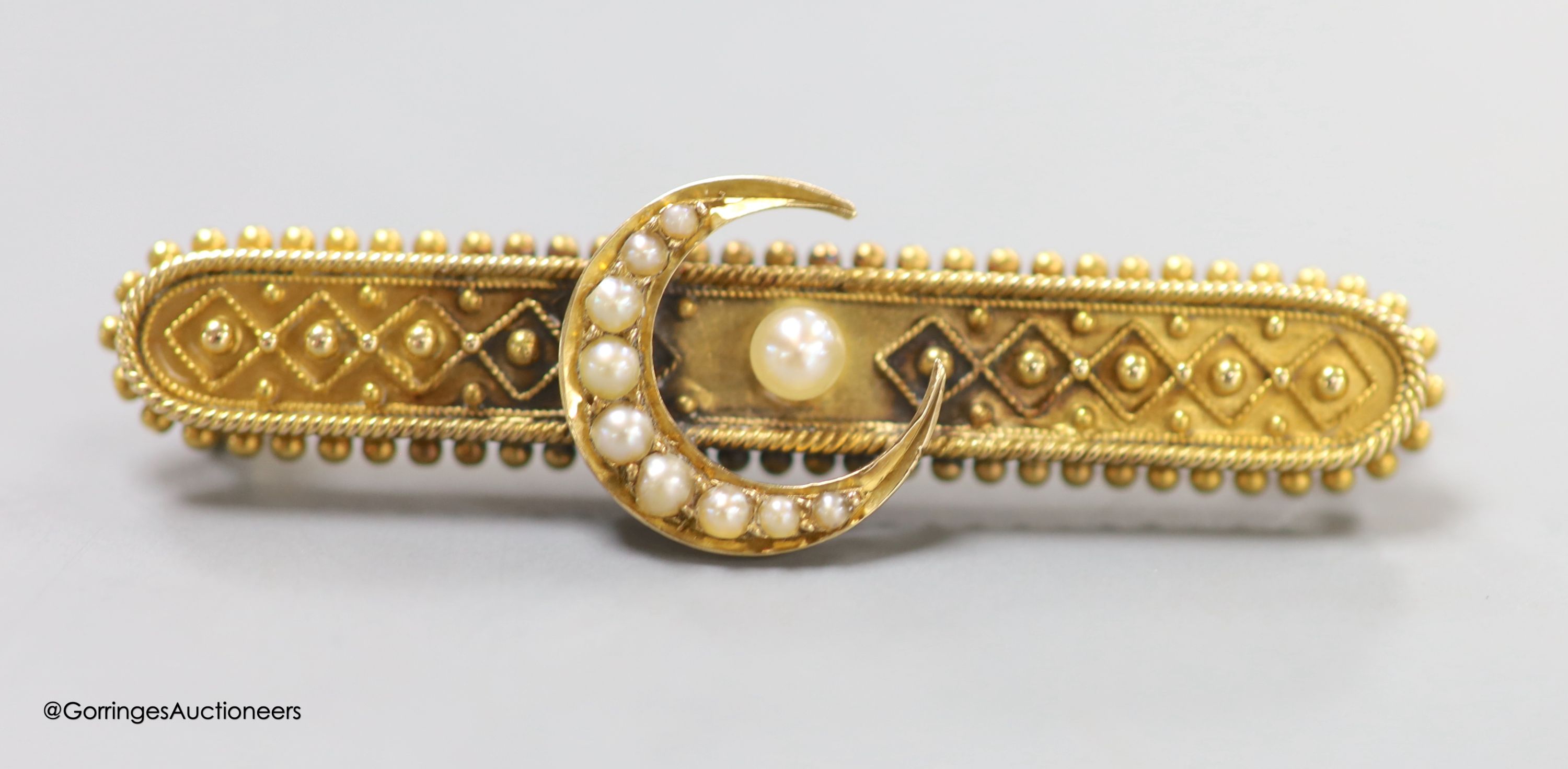 A late Victorian yellow metal and seed pearl set bar brooch, with crescent motif, 46mm, gross weight 5.2 grams.